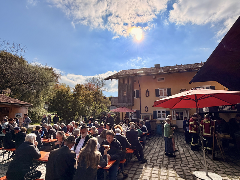 Weihung der Kapelle in Beigarten. Man sieht Teilnehmer im Hofgarten bei Kaffee und Kuchen bei strahlendem Sonnenschein.